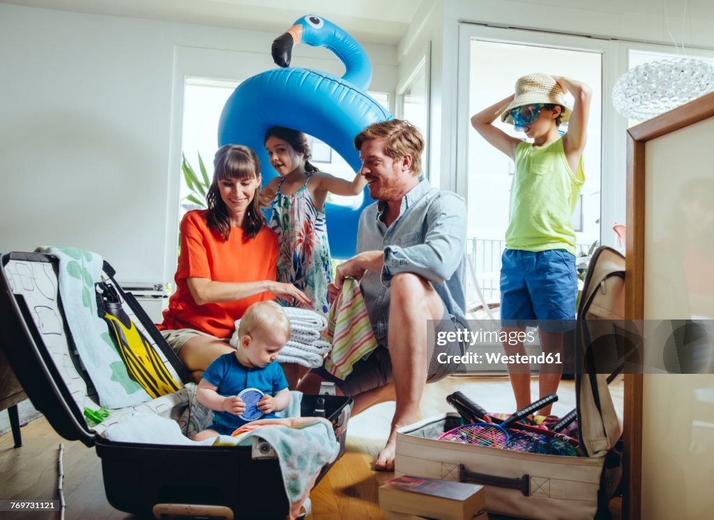 Happy family of five packing for holiday trip