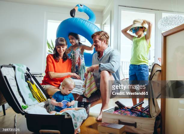 happy family of five packing for holiday trip - pak stockfoto's en -beelden