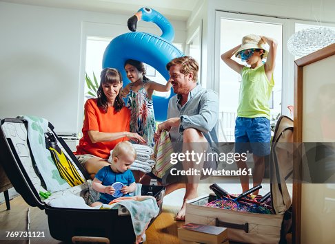 Happy family of five packing for holiday trip Happy family of five packing for holiday trip