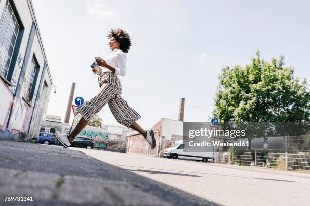 vital young woman crossing the street - licht von unten stock-fotos und bilder