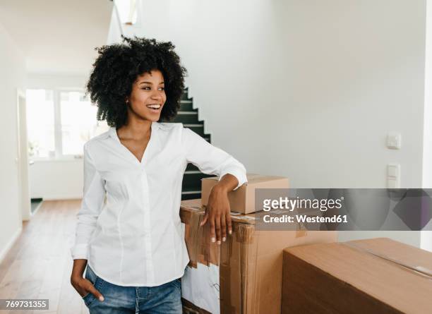 smiling young woman with cardboard boxes - new house imagens e fotografias de stock