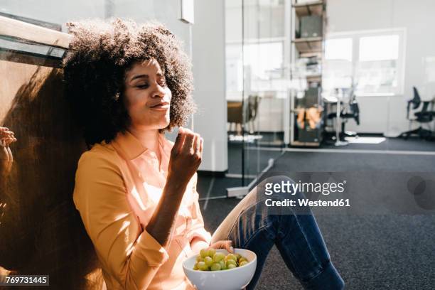 young woman having a break in office - speisen und getränke stock-fotos und bilder