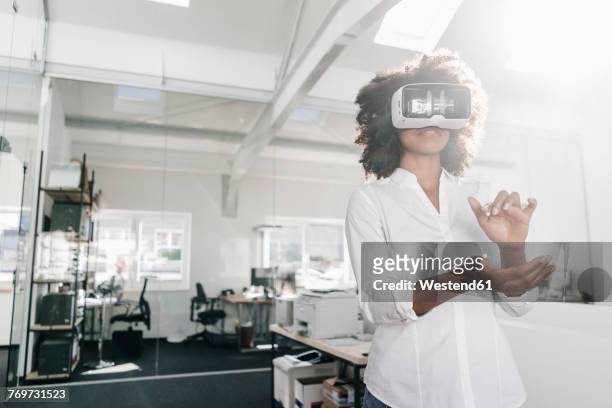 woman wearing vr glasses in office - augmented reality woman stock-fotos und bilder