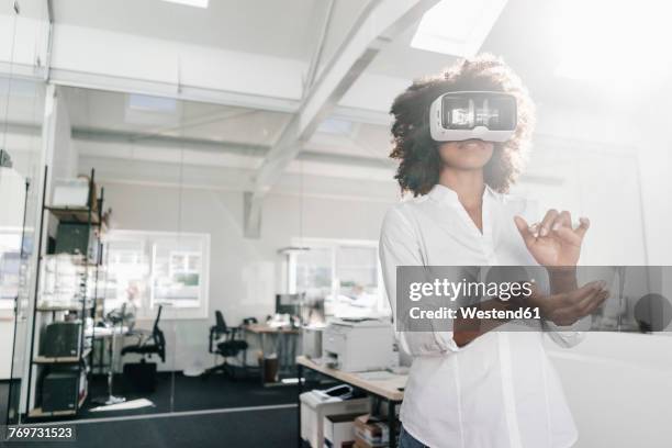 woman wearing vr glasses in office - vr imagens e fotografias de stock