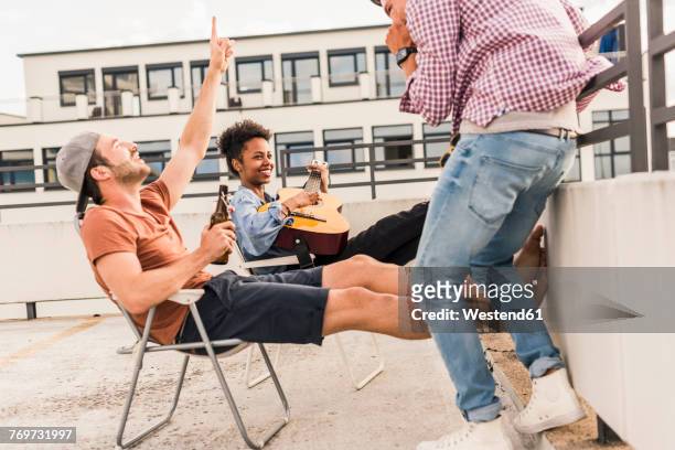 three friends having a rooftop party - campingstuhl stock-fotos und bilder