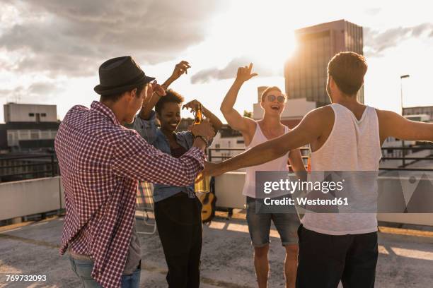 friends having a rooftop party - celebration of life and laughter stock-fotos und bilder
