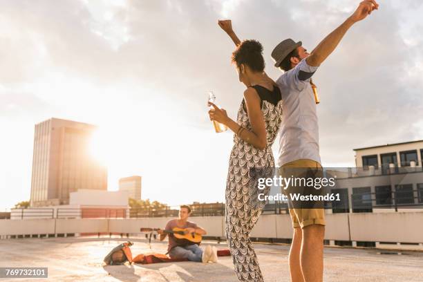 young couple dancing on a rooftop party - social action party stock pictures, royalty-free photos & images