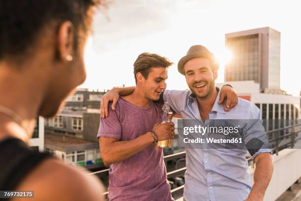 friends having a rooftop party - talking friends backlight stock pictures, royalty-free photos & images