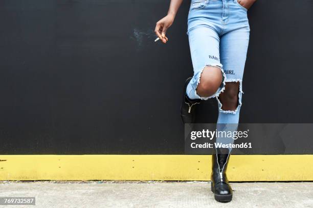 legs of woman wearing used look jeans - standing with hands on knees imagens e fotografias de stock