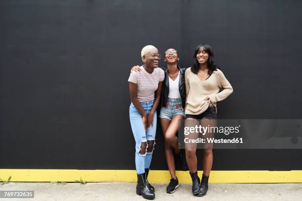 three friends standing against black background having fun - portrait copy space stock pictures, royalty-free photos & images