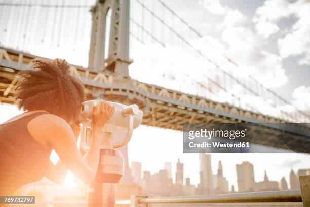 usa, new york city, brooklyn, woman looking through coin-operated binoculars at manhattan bridge - looking through binoculars stock pictures, royalty-free photos & images