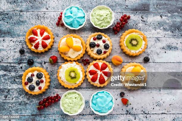 Mini pies with whipped cream garnished with different fruits