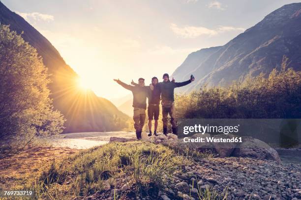 slovenia, bovec, three friends at soca river at sunset - drei erwachsene stock-fotos und bilder