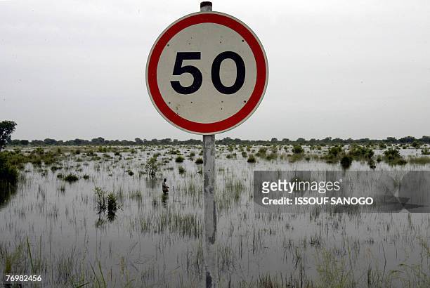 Road sign pokes out of the water 23 September 2007 near the village of Nasia in northern Ghana after the Volta Blanc river overflowed due to recent...