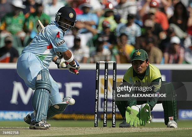 India's batsman Gautham Gambhir slams a shot off the ball of Pakistan's bowler Mohammad Hafeez as Kamran Akmal Wicketkeeper waits to make a catch...