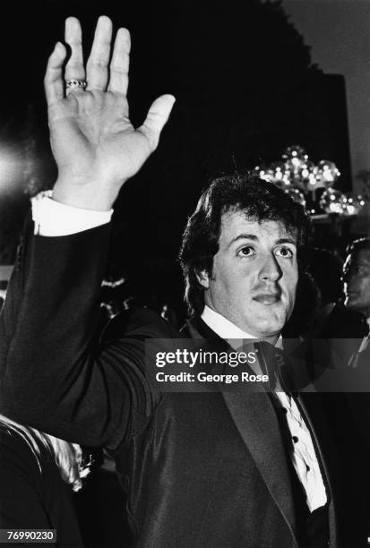 Star of the hit "Rocky" films, Sylvester Stallone, waves to the crowd as he enters the 1980 Los Angeles, California, Academy Awards ceremony at the...