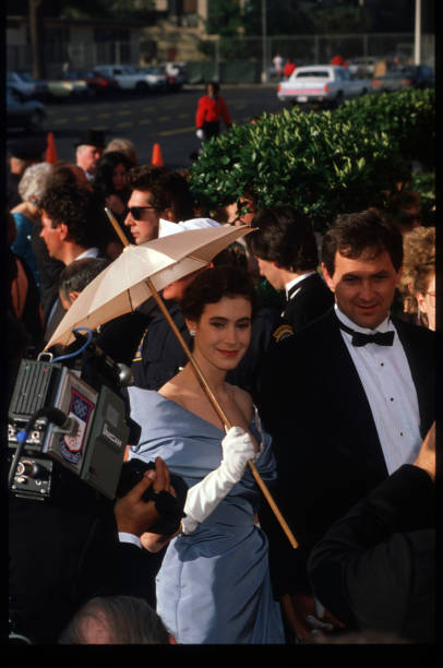 Actress Sean Young holds a parasol while standing next to an unidentified man at the 1988 Academy Awards April 11, 1988 in Los Angeles, CA. The...