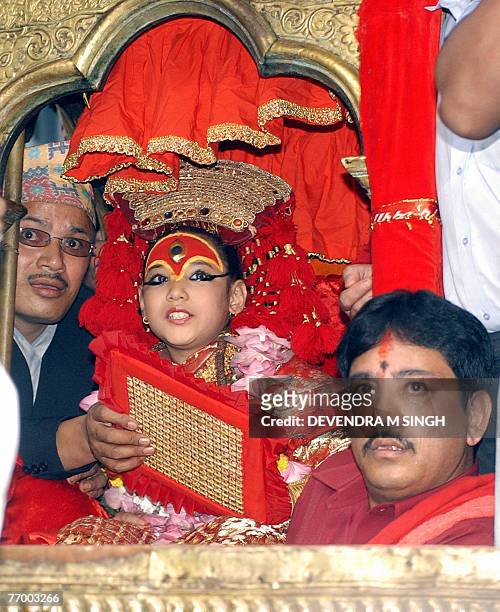 In this picture taken 06 September 2006, Kumari, a pre-pubescent girl revered by many in Nepal as a living goddess, is flanked by Buddhist priests...