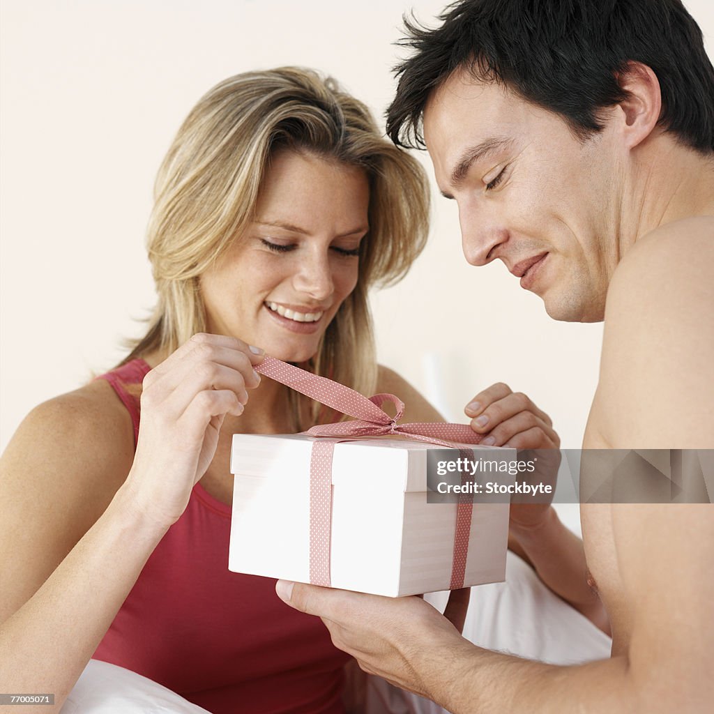 Man giving woman gift, indoors