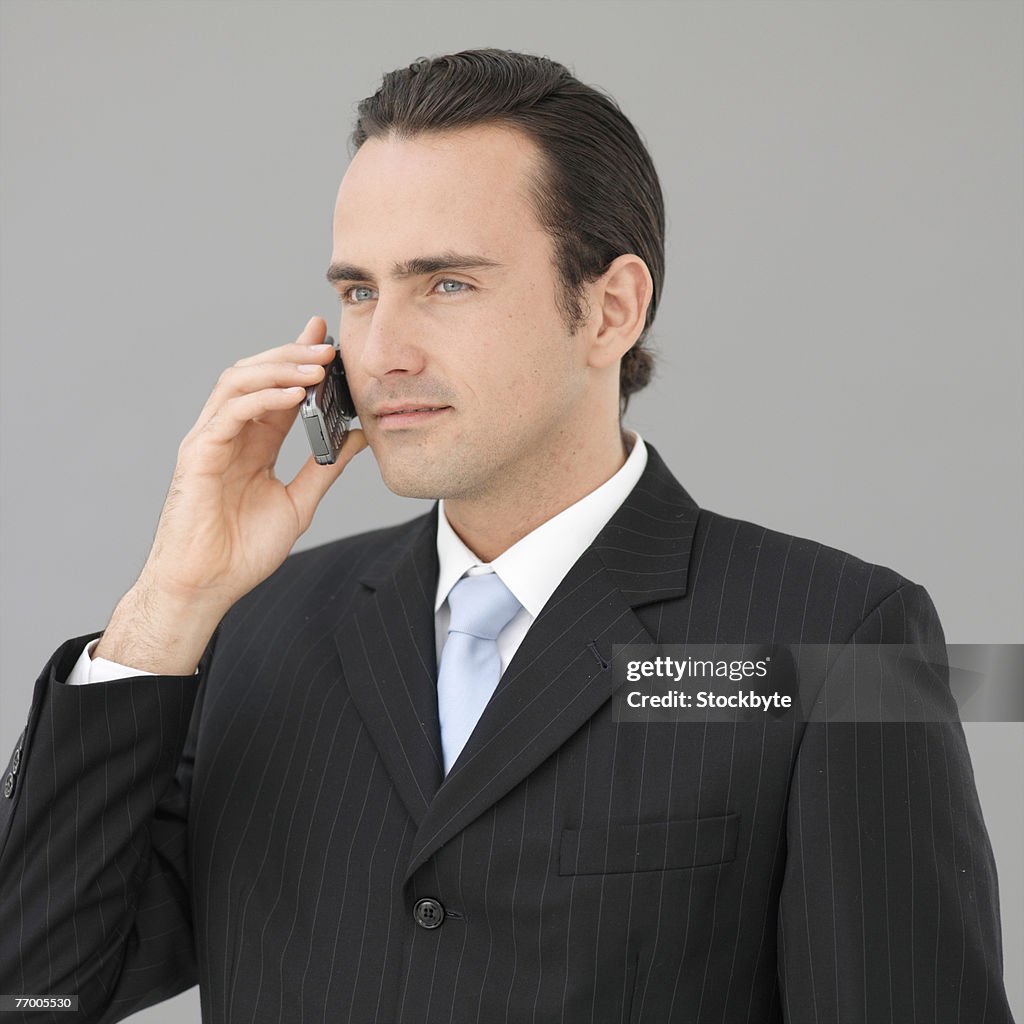 Business man using mobile phone, studio shot