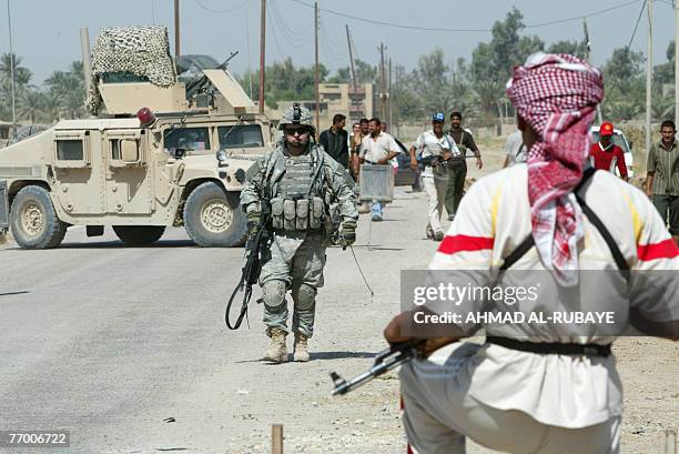 Former Iraqi insurgents , members of the Sunni Anbar Awakening, and US army soldiers, their former ennemies, guard a meeting between Sunni and Shiite...