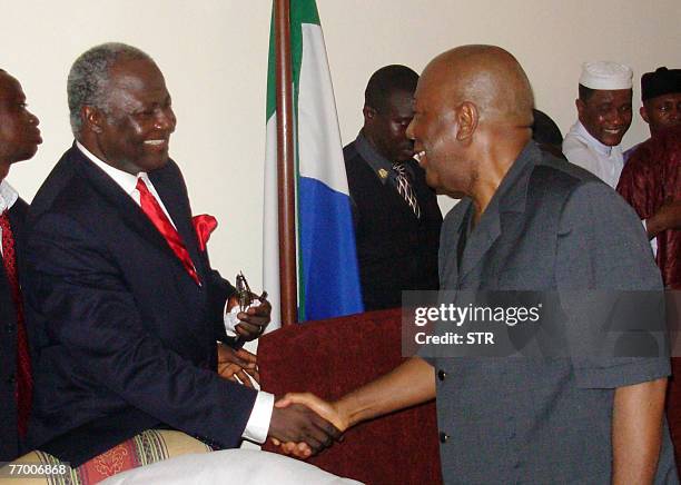 Newly elected president Ernest Bai Koroma shakes hands with outgoing leader Ahmad Tejan Kabbah 17 September 2007 in Freetown, after winning a tense...