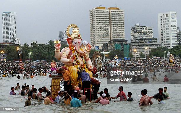 Indian Hindu devotees carry an idol of the elephant-headed Hindu God Lord Ganesha into the Arabian sea for immersion on the last day of the ten day...