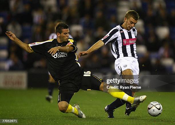 James Morrison of West Bromwich Albion is tackled by Joe Ledley of Cardiff City during the Carling Cup Third Round match between West Bromwich Albion...
