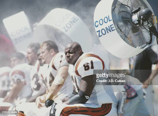 Melvin Tuten, Center for the Cincinnati Bengals sits on the bench to keep cool by the large air conditioning cooling fans during the American...