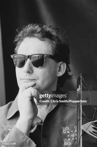 English professional snooker player Jimmy White posed wearing sunglasses holding his snooker cue case in England circa 1991.