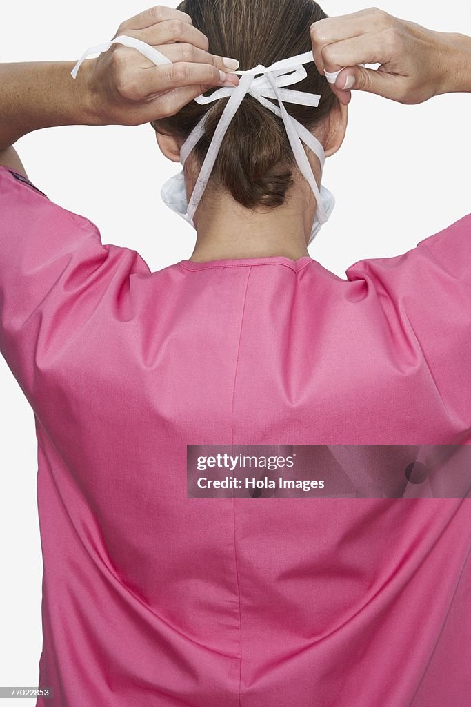 Rear view of a female doctor wearing a surgical mask