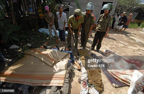 Policemen look at victims lying on the ground after the collapse of the Can Tho bridge under construction in Vietnam's southern province of Vinh...