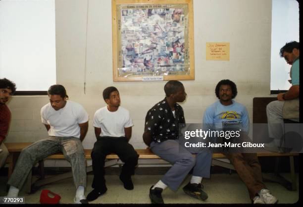 Arrested gang members sit on a bench June 10, 1988 in Los Angeles, CA. The Los Angeles Police Department swept through gang-ridden neighborhoods in...