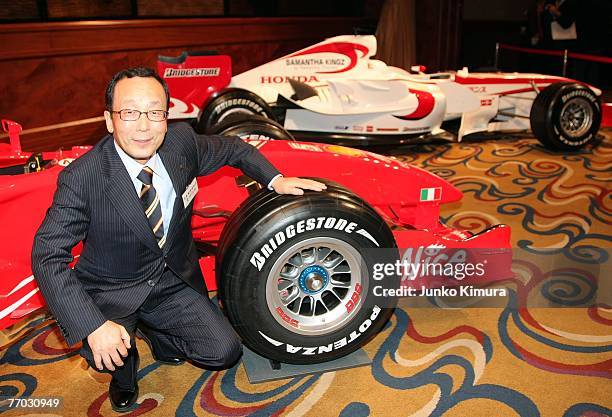 And President of Bridgestone Shoshi Arakawa poses next to the company's tire during a press conference on September 26, 2007 in Tokyo, Japan. The F1...