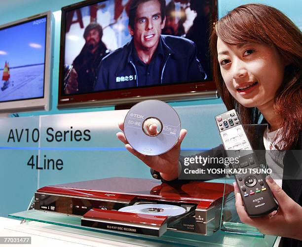 An employee for Japanese electronics giant Sharp displays the company's new Blu-ray Disc recorder "Aquos Blu-ray BD-AV10", which can record and play...