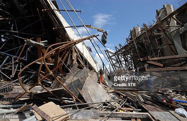 Rescue workers search the site of the collapse Can Tho bridge under construction in Vietnam's southern province of Vinh Long, 26 September 2007. At...