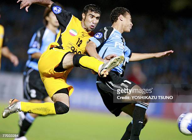 Iran's Sepahan midfielder Abdul Wahab Abu Al Hail shoots the ball while Japan's Kawasaki Frontale midfielder Magnum Tavares attempts to block the...
