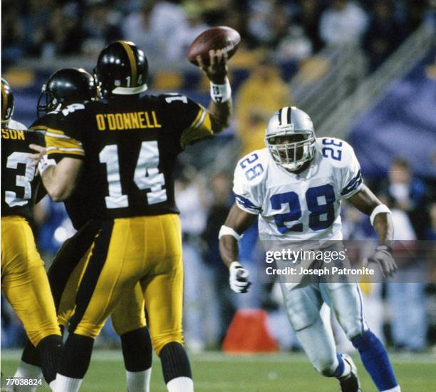 Dallas Cowboys defensive back Darren Woodson blitzes Pittsburgh Steelers quarterback Neil O'Donnell as he throws a pass during the Cowboys 27-17...