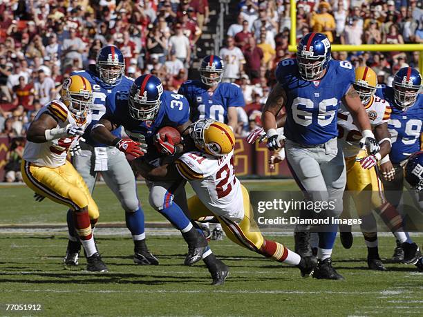 Runningback Derrick Ward of the New York Giants tries to break the tackle of safety Sean Taylor of the Washington Redskins during a game on September...