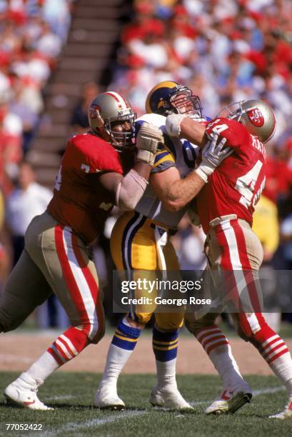 Full back Tom Rathman and tackle Steve Wallace of the San Francisco 49ers team up to block against Los Angeles Rams linebacker Kevin Greene a game at...