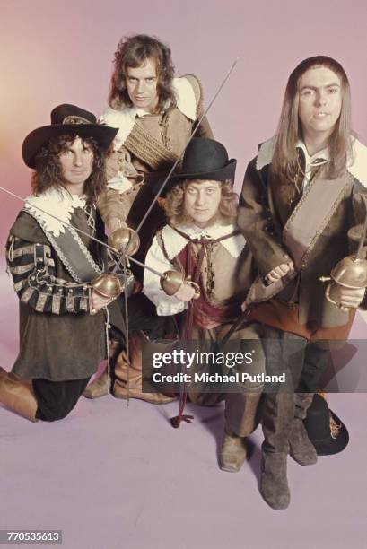 English rock group Slade, posing in cavalier costumes and holding swords, London, 1974. The group are, from left to right: drummer Don Powell,...