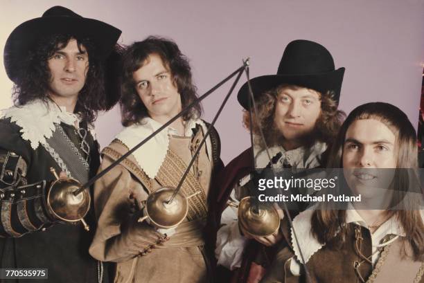 English rock group Slade, posing in cavalier costumes and holding swords, London, 1974. The group are, from left to right: drummer Don Powell,...