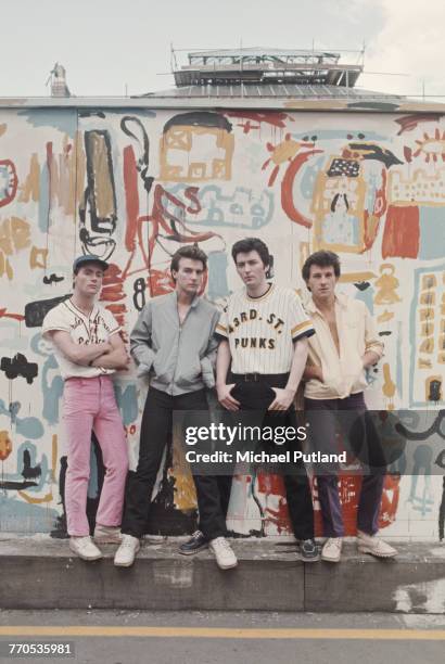 Scottish pop group Slik posed together wearing baseball tops, blouson jackets and Kickers boots in front of a painted backdrop in London, 20th May...