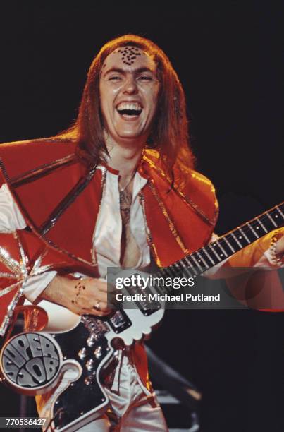 Guitarist Dave Hill of English glam rock group Slade, performs live on stage playing his specially made 'Superyob' guitar during the band's 'Crazee...