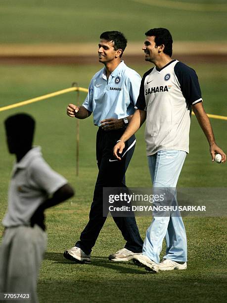 Indian cricketer Zaheer Khan enjoys a light moment with former captain Rahul Dravid during a training session at the Chinnaswamy Stadium in...