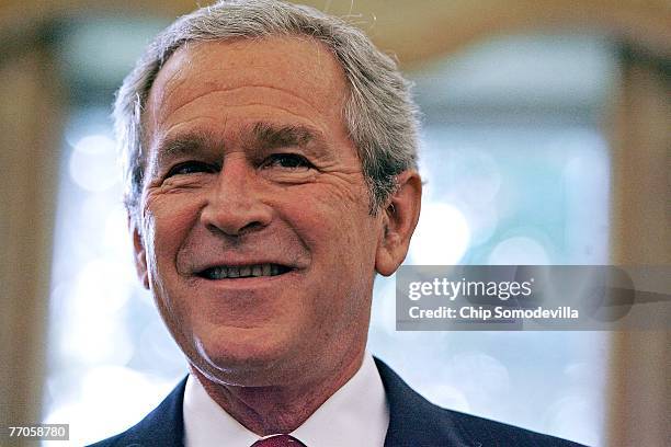 President George W. Bush poses for photographs with the Big Brothers and Big Sisters of the Year in the Oval Office September 27, 2007 in Washington,...