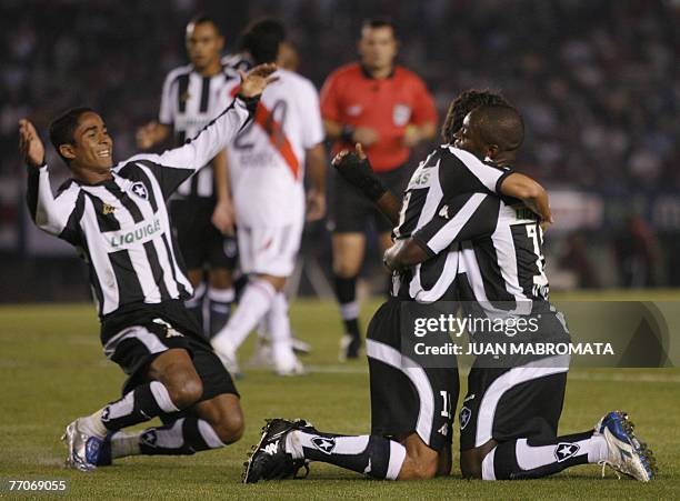 Midfielder Lucio Flavio of Brazil's Botafogo celebrates with teammates forwards Ze Roberto and Jorge Henrique after scoring against Argentina's River...
