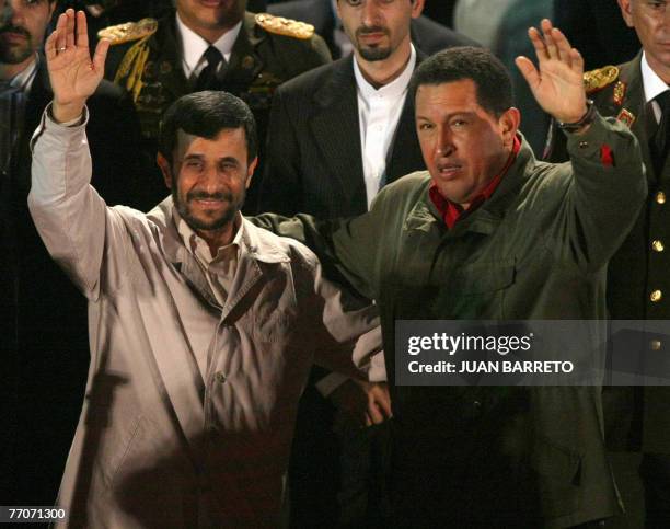 Venezuelan president Hugo Chavez and his Iranian counterpart Mahmoud Ahmadinejad wave to the crowd 27 September at the Miraflores presidential palace...