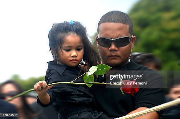 Jace-Lynn Tolentino niece of Sgt. Alexander Udarbe Gagalac of Wahiawa, Hawaii throws her rose on her uncle's grave as Joseph Tolentino, Gagalac's...