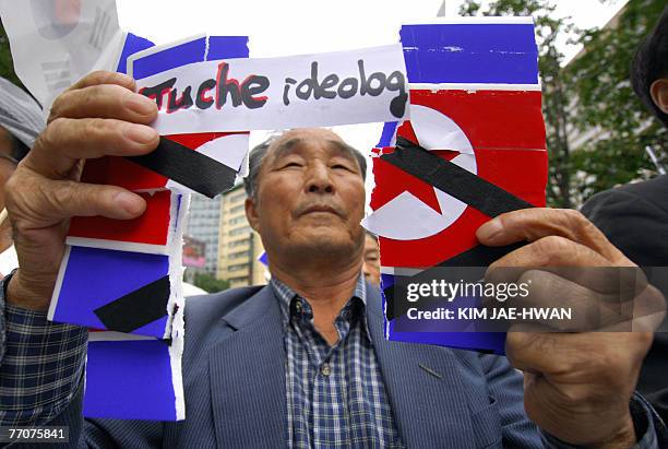 South Korean protester tears up a North Korean flag placard during an anti-North Korea rally in Seoul, 28 September 2007, against a planned 02-04...